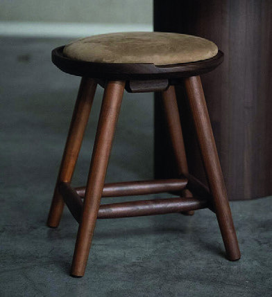 Home & Trends interieurselectie: Ronde houten kruk met een donkerbruine afwerking en zichtbare houtstructuur.