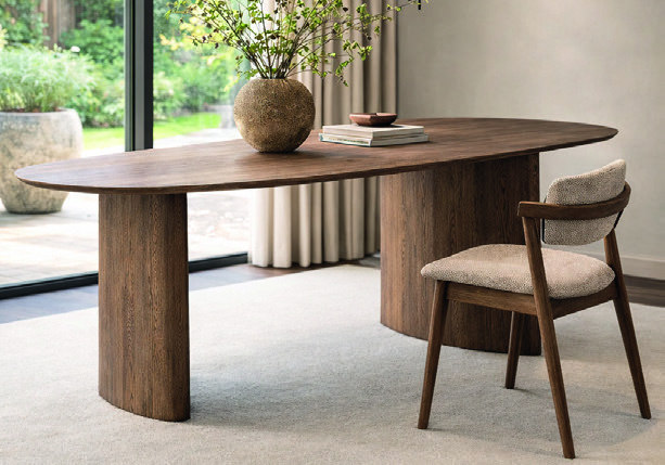 Home & Trends interieurselectie: Houten eettafel met een massief blad en robuuste tafelpoten in een lichtrijke ruimte.
