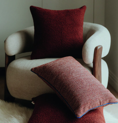 Home & Trends interieurselectie: Zachte sierkussens in roodbruine en beige tinten geven de fauteuil een warme uitstraling.