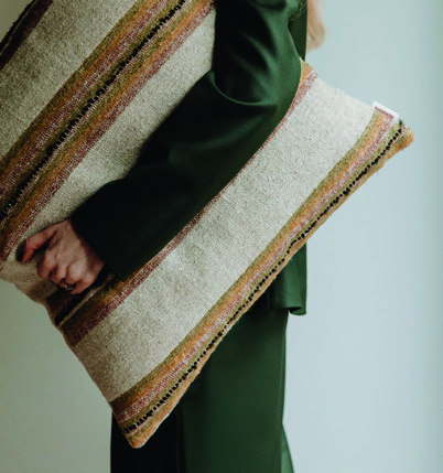 Home & Trends interieurselectie: Gelaagde textielen en plaids in natuurlijke kleuren, gedragen in een sfeervolle interieursetting.