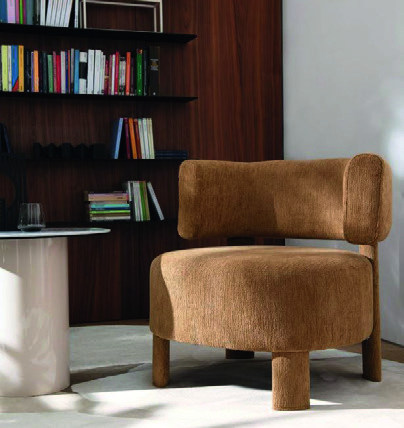 Glen fauteuil in warme bruine stof, voor een houten boekenwand